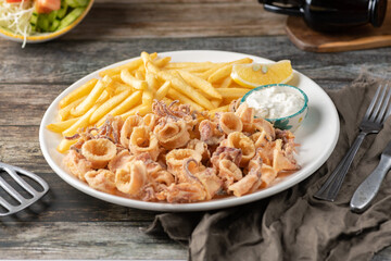 Fried squid, also known as calamari, are sliced into rings, lightly battered, and deep-fried until...