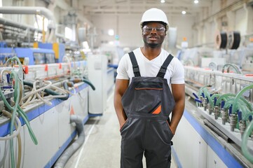 Professional Heavy Industry Engineer Worker Wearing Uniform, Glasses and Hard Hat in a Factory