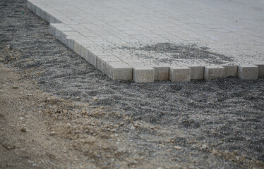 Paved surface in construction with paving stones and gravel, close-up