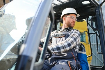 A man on a forklift works in a large warehouse, unloads bags of raw materials © Serhii