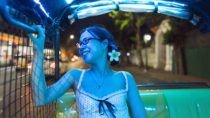 Asian woman traveler transpotation via tuk tuk local taxi enjoy night life travel in Bangkok city,...