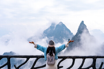 Young female tourist enjoying beautiful nature landscape with mist at Tianmen Shan national park, The famous tourist destination at Zhangjiajie - 791403982
