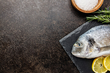 Fresh sea bream fish on cutting board on kitchen table. Top view. - 791404107