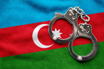 Flag of Azerbaijan and police handcuffs. Crime and offenses in country Concept
