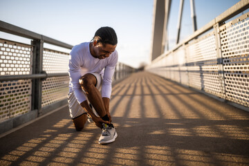 Young african-american man is injured while jogging. He twisted his ankle. - 791406353