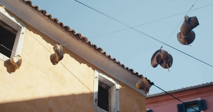 Straw hats hang on a wire in mediterranean town blue sky travel scene