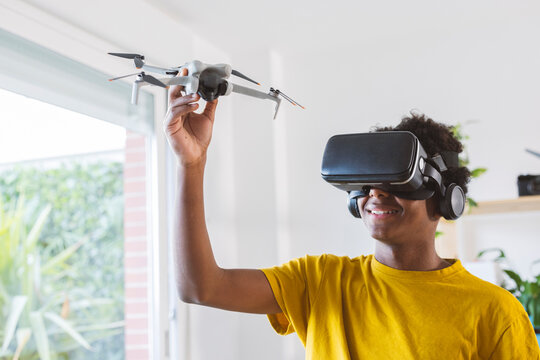 Teenage boy in VR glasses learning to operate drone