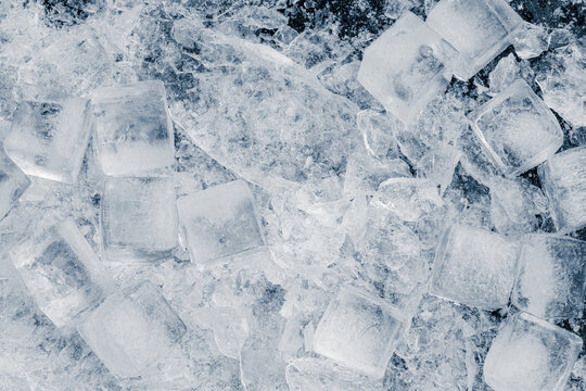 A heap of crushed ice cubes on a black background.