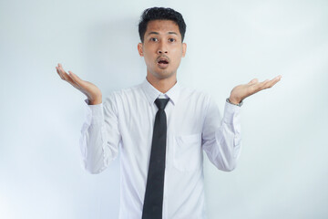 I don't know. Young man isolated on white background being at a loss, showing helpless gesture with...