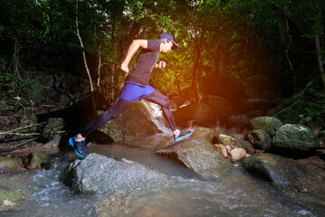 Runner, he's running a trail. In a natural path with a stream
