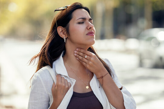 Young woman with throat allergy at street