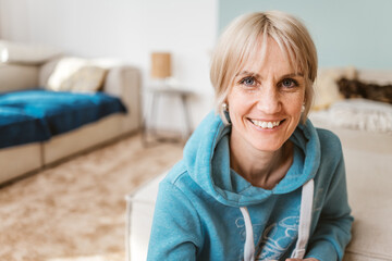 Smiling Woman with Short Blonde Hair in Cozy Living Room