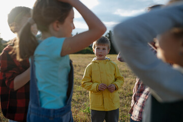 Portrait of young classmate playing hand clapping game outdoors. Students during field teaching...