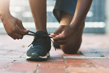 Hands, outdoor and tie shoes for fitness, exercise or start workout for sports in summer. Sneakers, person and runner tying shoelace to prepare for training, health and wellness on ground in city.