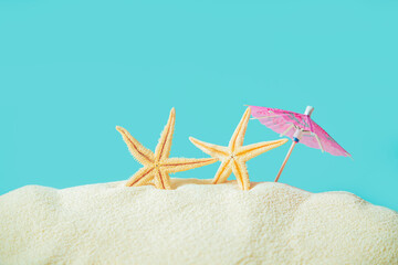 Starfish with a sun umbrella on a sandy beach.