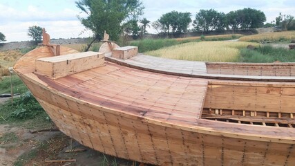 A large handmade wooden boat. A pair of boats are being prepared on the banks of the Indus River in Pakistan. Repair the wooden Boat with the ancient knowledge with saw,chisel,axe and some electric.4K