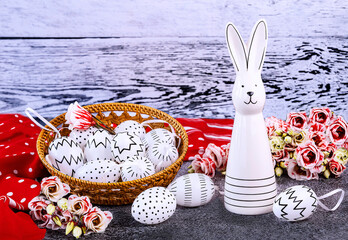 Easter composition with an Easter bunny, white eggs with black polka dots, a red polka dot shawl, a bouquet of eustoma flowers. Happy Easter concept