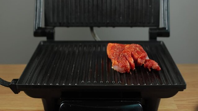 Electric grill, cooking pork. Grilled meat, homemade barbecue. Let's fry a juicy steak. Tasty and appetizing pork. We prepare meat steaks at home
