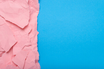 Pieces of torn pink paper on blue background. Space for text. Background, paper texture.
