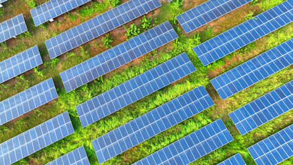 From above, a solar panels unfolds, each a note in a composition of sustainability. Like a patchwork quilt, they capture the sun's energy, painting the landscape in hues of green innovation.
 - obrazy, fototapety, plakaty