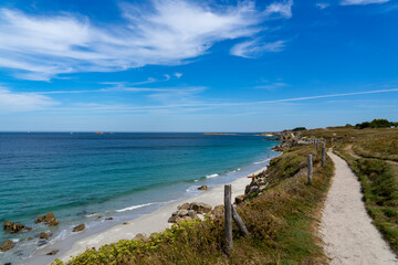 Au sommet des falaises, un sentier côtier offre une vue sur les plages de sable blanc et les eaux turquoise du littoral breton, dans le Finistère nord.