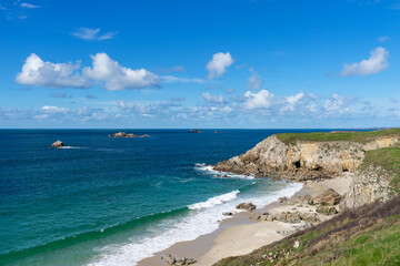 Fototapeta premium Au pied des falaises, plages de sable blanc, rochers éparpillés dans des eaux cristallines et turquoise du littoral breton dans le Finistère nord