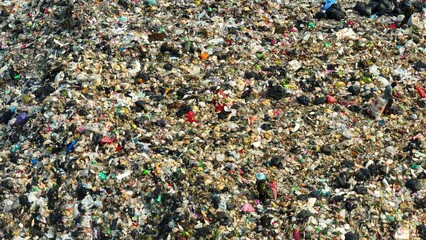 An overwhelming amount of waste, with noticeable scraps of plastic, paper, and other refuse scattered throughout, reflecting the magnitude of waste humans generate.
