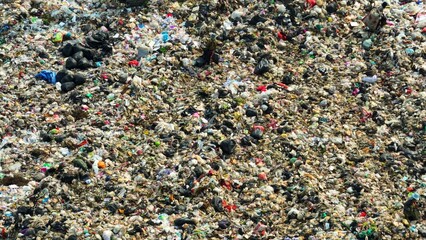 Waste sprawls in disorder, a stark reminder of trash accumulation and consequences of consumption...