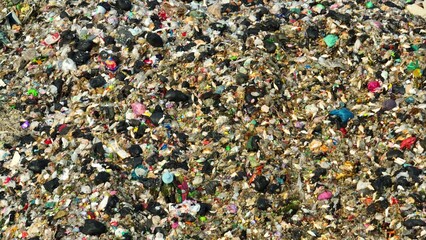 A cluttered terrain of waste, including various plastics and discarded items, a testament to the...