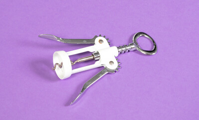Old bottle opener isolated on solid purple background