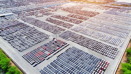 An aerial panorama unveils a sea of cars, meticulously positioned in parallel lines, creating a...