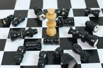 One King Chess as A Winner with Black Chess Pieces Falling on Chessboard