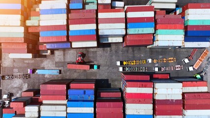 Fototapeta premium A bird's-eye vista of the container terminal reveals a kaleidoscope of colorful cargo containers and miniature vehicles, forming a mesmerizing geometric tapestry below. 