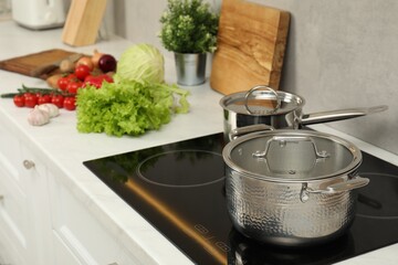 Cooking dinner. Pot, saucepan and fresh vegetables on countertop in kitchen