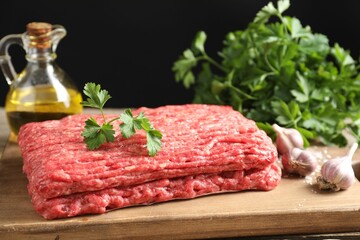 Raw ground meat, garlic, oil and parsley on table