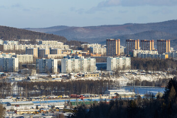 Tynda city, Amur region, Siberia, Russia. Winter city landscape. View of residential buildings. Mountains in the distance. - 791428936