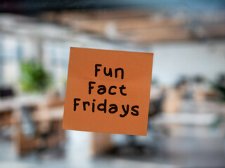 Post note on glass with 'Fun Fact Fridays', team building, game at work, office game, fun in enterprise.