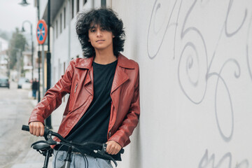 young latin hispanic man with bike on the street
