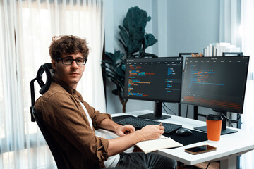 IT developer in online software development information looking at camera surrounded coding pc...