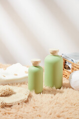 Bath accessories from natural ingredients, green bottles without label featured on brown carpet against white background. Front view photo, copy space