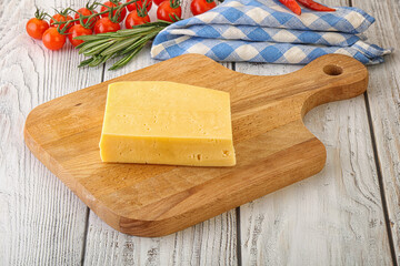 Piece of natural organic cheese over board - obrazy, fototapety, plakaty