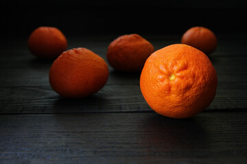 Concept, hands in black rubber gloves hold ripe tangerine fruits. Citrus fruits contrast well...