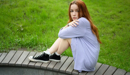 Beautiful girl with red hair is enjoying the summer days. - 791436946