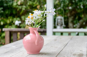 花瓶に挿した花、屋外のテラステーブル、水仙の花