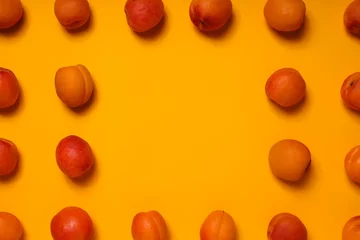 Rolgordijnen Fresh juicy apricots on a yellow background © Atlas