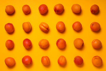 Fresh juicy apricots on a yellow background
