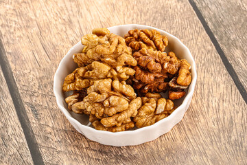 Cracked unshelled walnut in the bowl