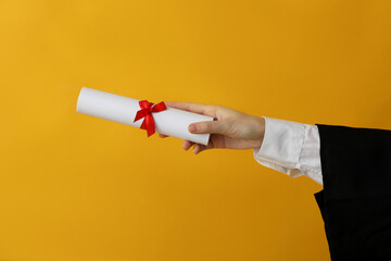 Diploma of a university graduate, on a yellow background.
