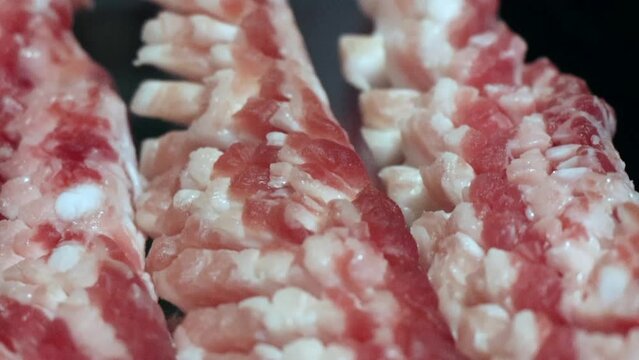 칼집낸 벌집삼겹살을 불판에서 구우며 나오는 육즙과 기름 클로즈업