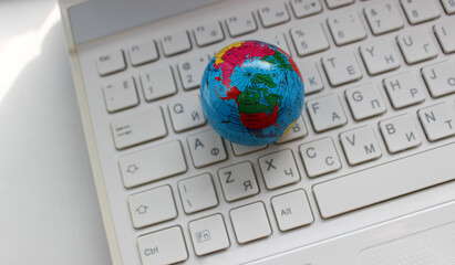 Top view of the North Pole, oceans and parts of continents on a white bilingual laptop keyboard